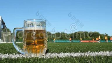 一杯啤酒在足球场上，足球在体育场上进行